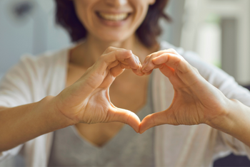 A woman making the shape of a heart with her hands