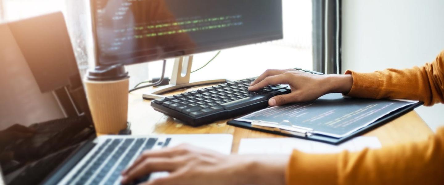 A person typing on two different computer keyboards