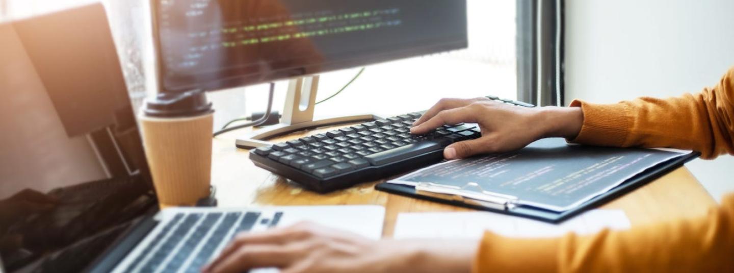 A person typing on two different computer keyboards