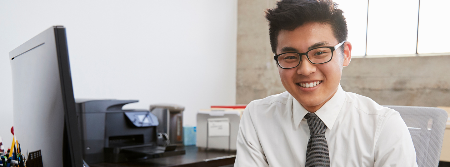 A young professional sitting by his computer