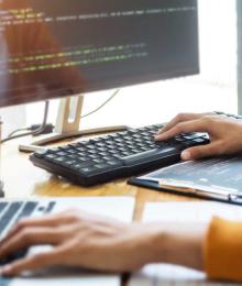 A person typing on two different computer keyboards