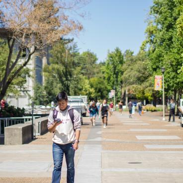 Students walking in front of Darwin Hall along the main campus walkway