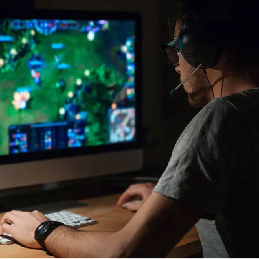 A man  looking at a computer screen,working on a video game